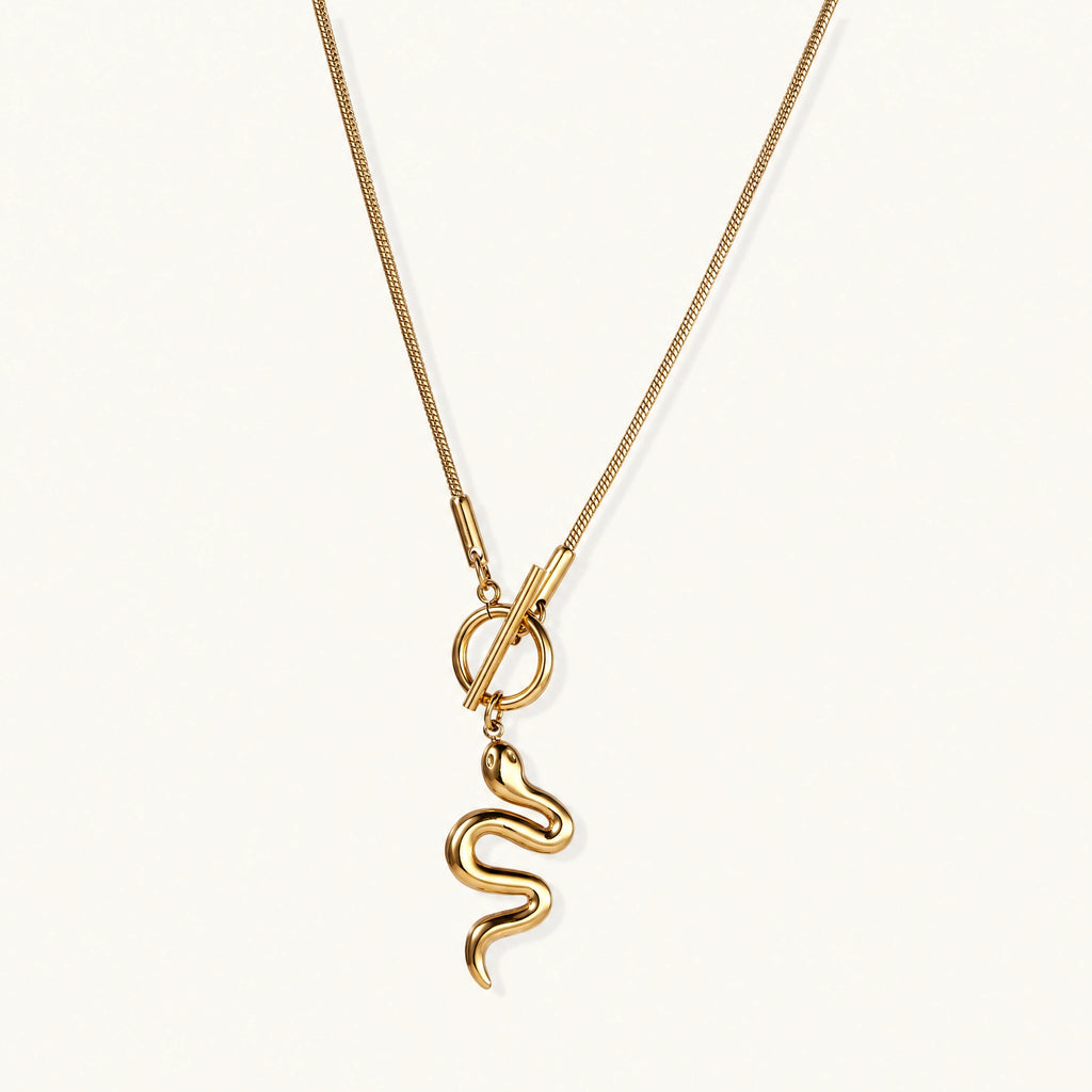 Sculptural gold snake pendant on delicate chain with toggle clasp, featuring smooth curves and polished 14K gold plated finish