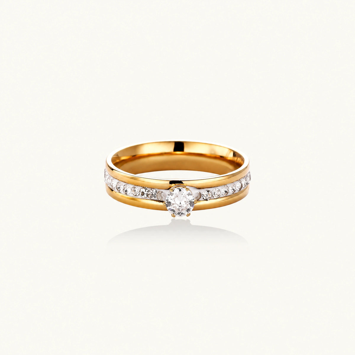 Gold-plated double-band ring with center rhinestone solitaire and channel-set stones on white background