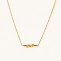 Dainty 18K gold plated necklace with infinity knot pendant on delicate chain against white background