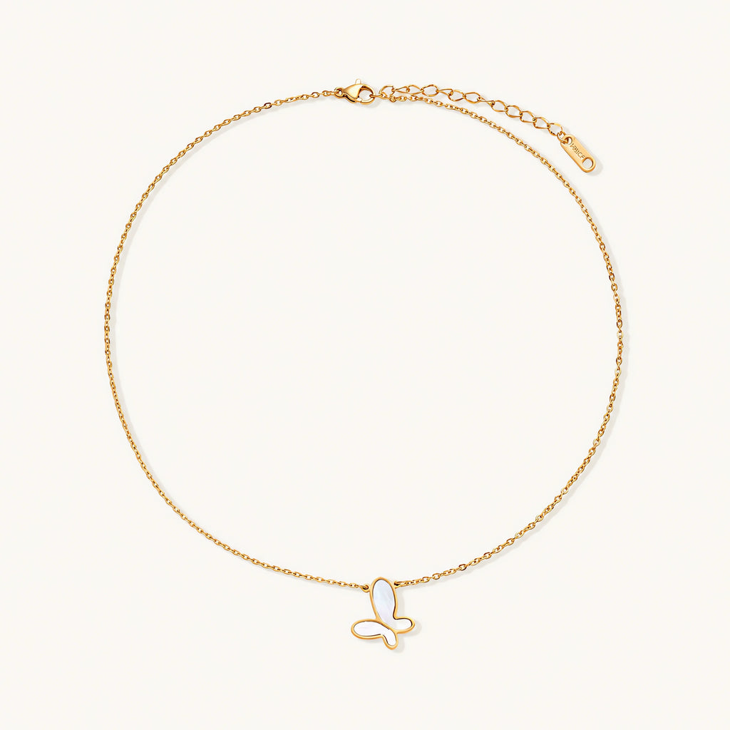 Gold-plated butterfly pendant with iridescent mother of pearl inlay on delicate chain against cream background.