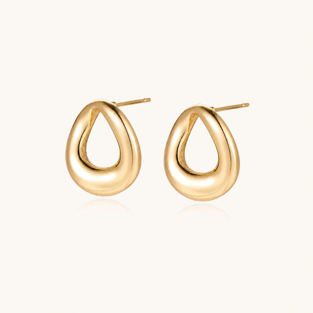 Pair of polished 18K gold-plated stainless steel teardrop earrings with hollow centers on cream background
