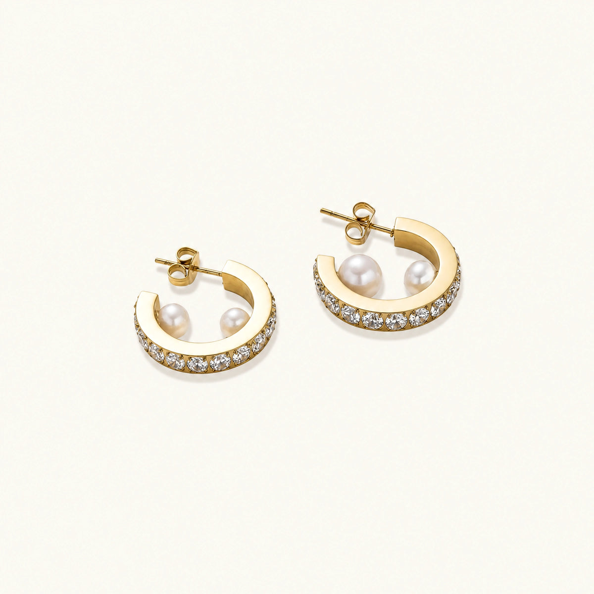Gold pavé hoop earrings with two freshwater pearls nestled inside the curved design, featuring crystal-studded outer edge.
