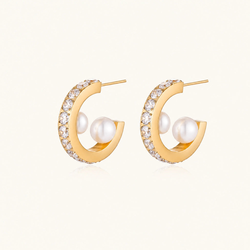 Gold pavé hoop earrings with two freshwater pearls nestled inside the curved design, featuring crystal-studded outer edge.