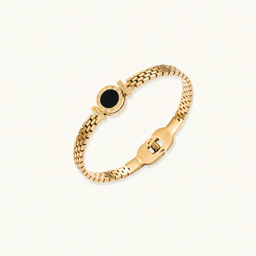 Gold mesh bracelet with circular black mother of pearl medallion featuring Roman numeral engravings and hinged clasp