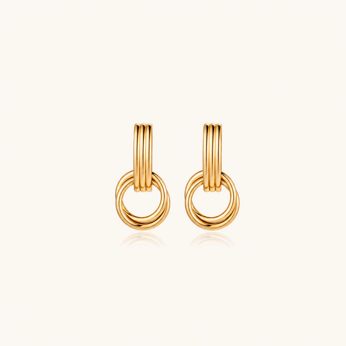 Gold stud earrings with vertical ridged bar connecting to triple interlocking circular rings on white background