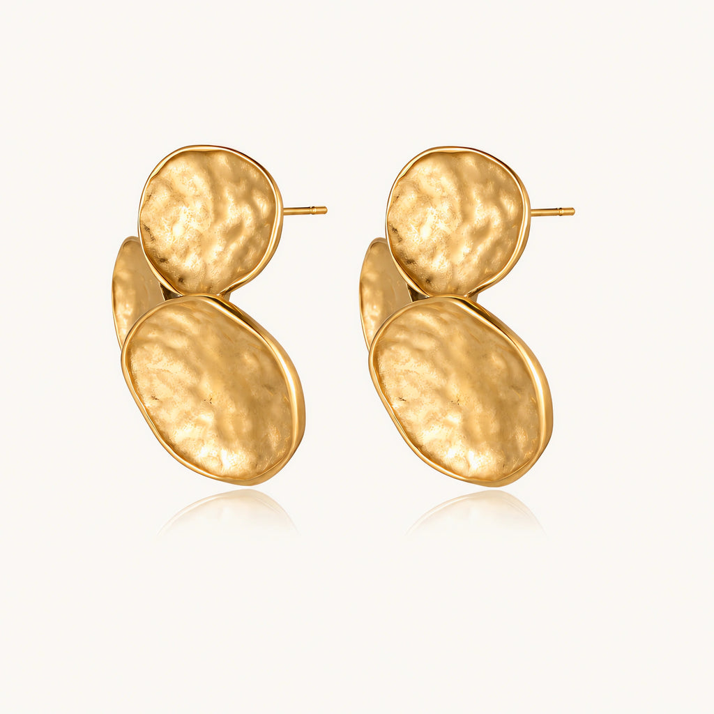 Three hammered gold discs clustered together forming organic statement earrings with textured surfaces