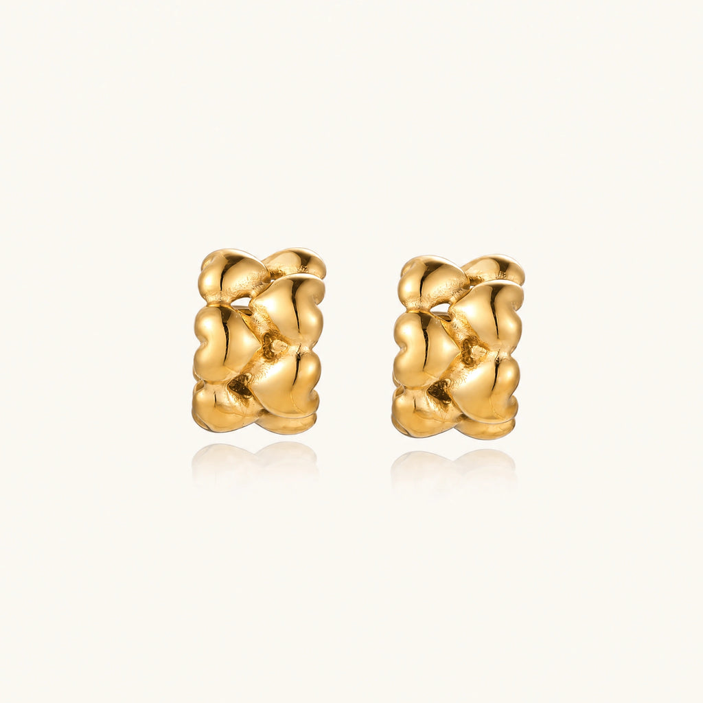 Close-up of gold-plated twisted rope huggie hoop earrings with brushed finish on white background.