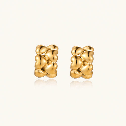 Close-up of gold-plated twisted rope huggie hoop earrings with brushed finish on white background.