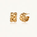 Close-up of gold-plated twisted rope huggie hoop earrings with brushed finish on white background.