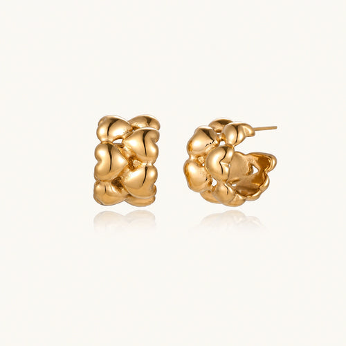Close-up of gold-plated twisted rope huggie hoop earrings with brushed finish on white background.