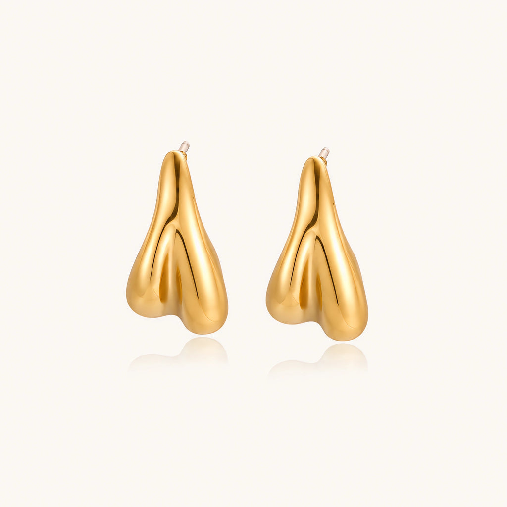 Organic sculptural gold stud earrings with fluid matte finish on cream background