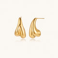 Organic sculptural gold stud earrings with fluid matte finish on cream background